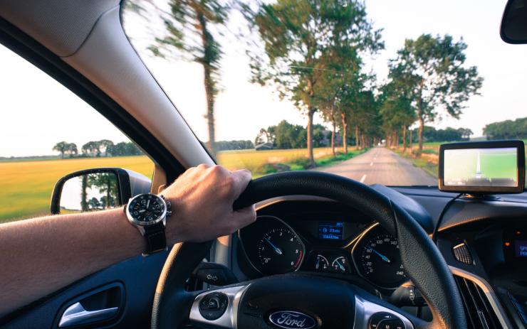 Uomo che guida l'auto d'estate