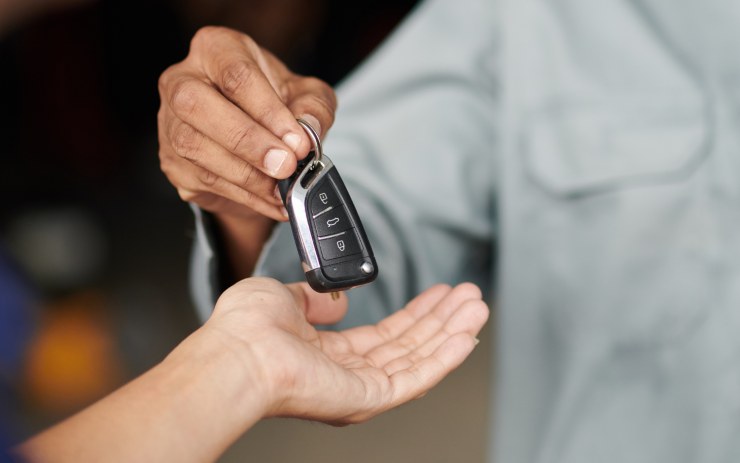 Uomo che vende la sua auto e cede le chiavi
