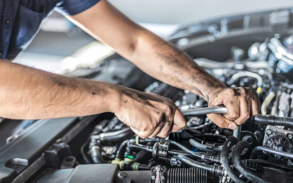 Meccanico che aggiusta il motore dell'auto