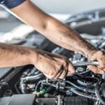 Meccanico che aggiusta il motore dell'auto