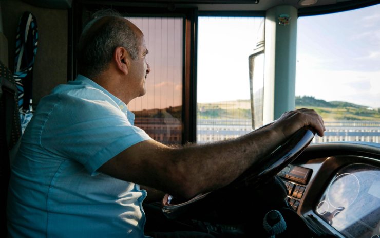 Sessantenne che guida un autobus
