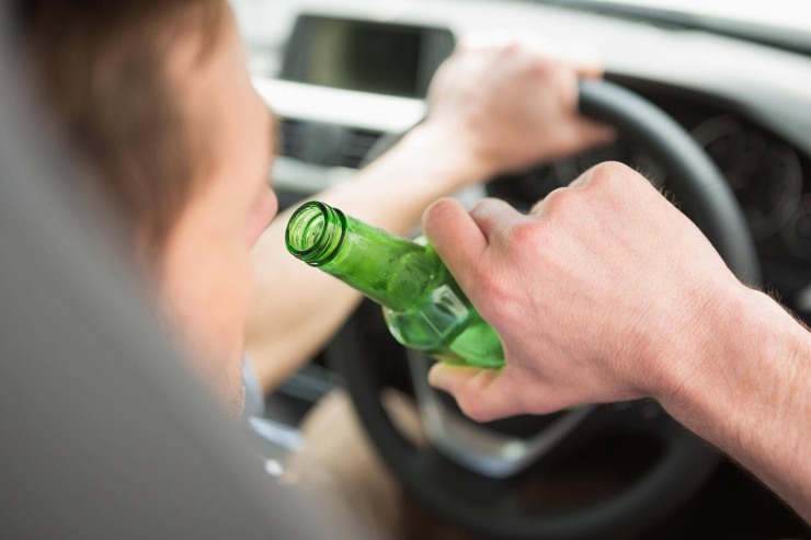 Uomo che beve una birra alla guida