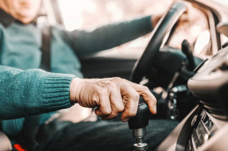 Mano di un signore over 60 alla guida