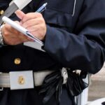 Vigile che scrive una sanzione