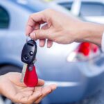 Uomo che dà le chiavi dell'auto ad un altro conducente: vendita dell'usato