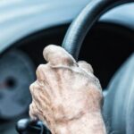 Mano di un'anziana al volante dell'auto