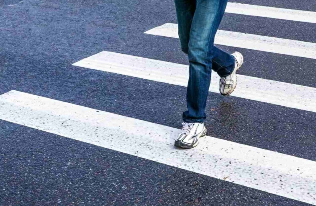 Uomo che attraversa sulle strisce pedonali