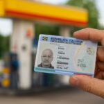 Sfondo di un benzinaio e mano in primo piano che mostra la carta d'identità elettronica