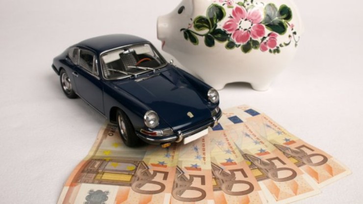 Banconote euro, salvadanaio e modellino di un'auto d'epoca
