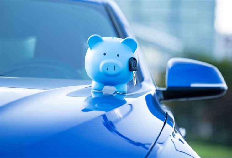 salvadanaio azzurro sopra al cofano di un'auto blu