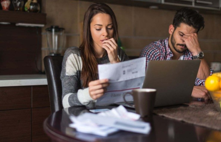 Coppia preoccupata che legge la comunicazione sul fallimento della propria compagnia assicurativa