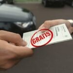Due persone che si scambiano il passaggio con auto sullo sfondo. Timbro rosso con scritto "gratis"