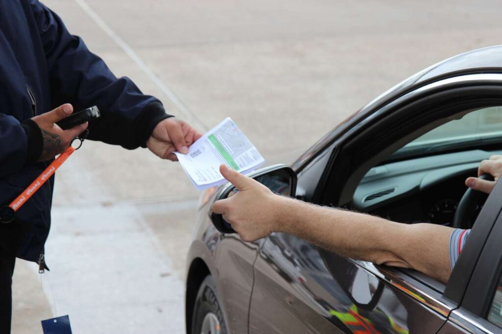 Conducente che dà un documento al posto di blocco