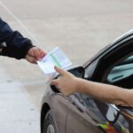 Conducente che dà un documento al posto di blocco