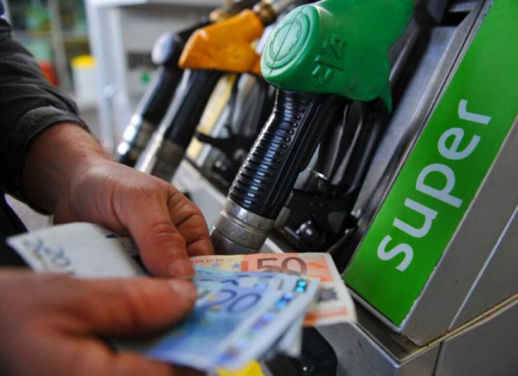 Pompa di benzina e uomo con banconote euro in mano