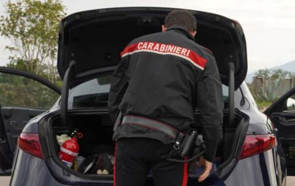 Carabiniere che controlla un bagagliaio