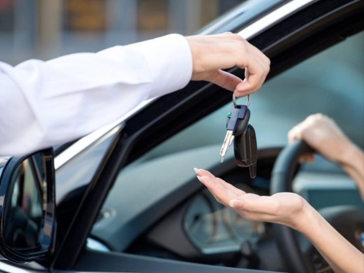 Uomo che dà le chiavi a una donna in auto