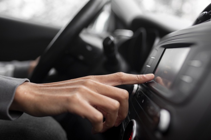Persona che cambia canale della radio auto
