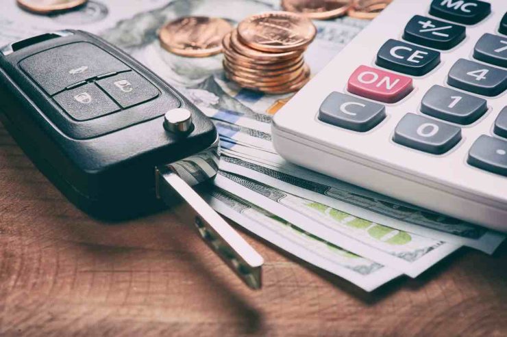 Chiave auto, banconote e calcolatrice