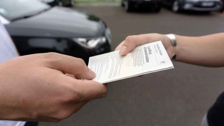 Una persona che passa il foglio del passaggio di proprietà al nuovo conducente