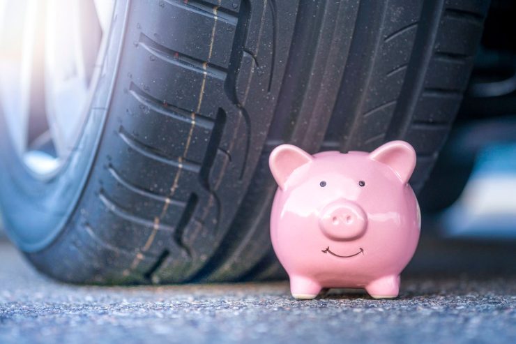 Salvadanaio vicino a una ruota dell'auto