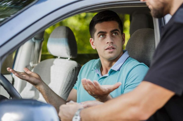 Conducente che discute con l'agente al posto di blocco