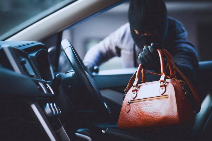 Ladro che ruba una borsa in auto