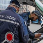 Due agenti della Polizia locale che scrivono un verbale