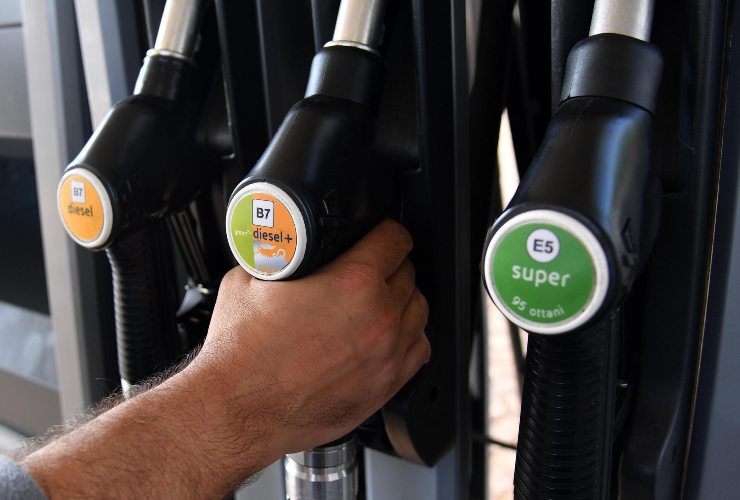 Uomo che tiene in mano la pompa del diesel