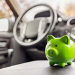 Salvadanaio verde sopra al sedile di un'auto