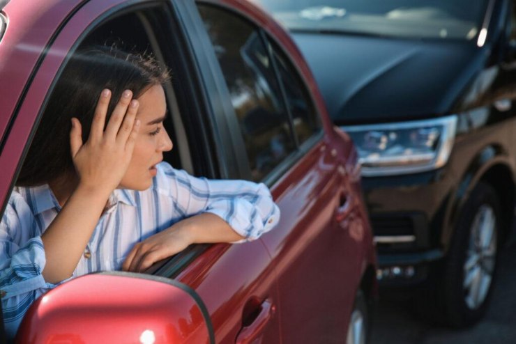 Ragazza che si guarda dietro dopo un tamponamento alla sua auto