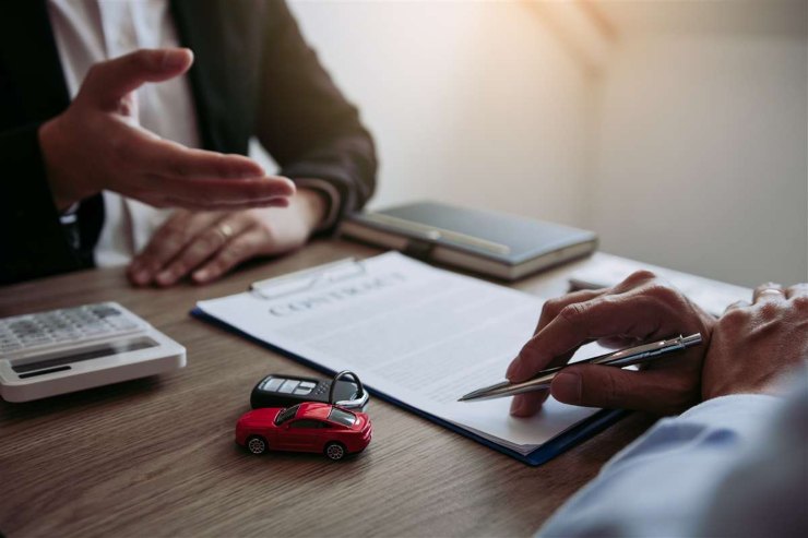 Cliente e rappresentante assicurativo di fronte a un contratto di assicurazione auto