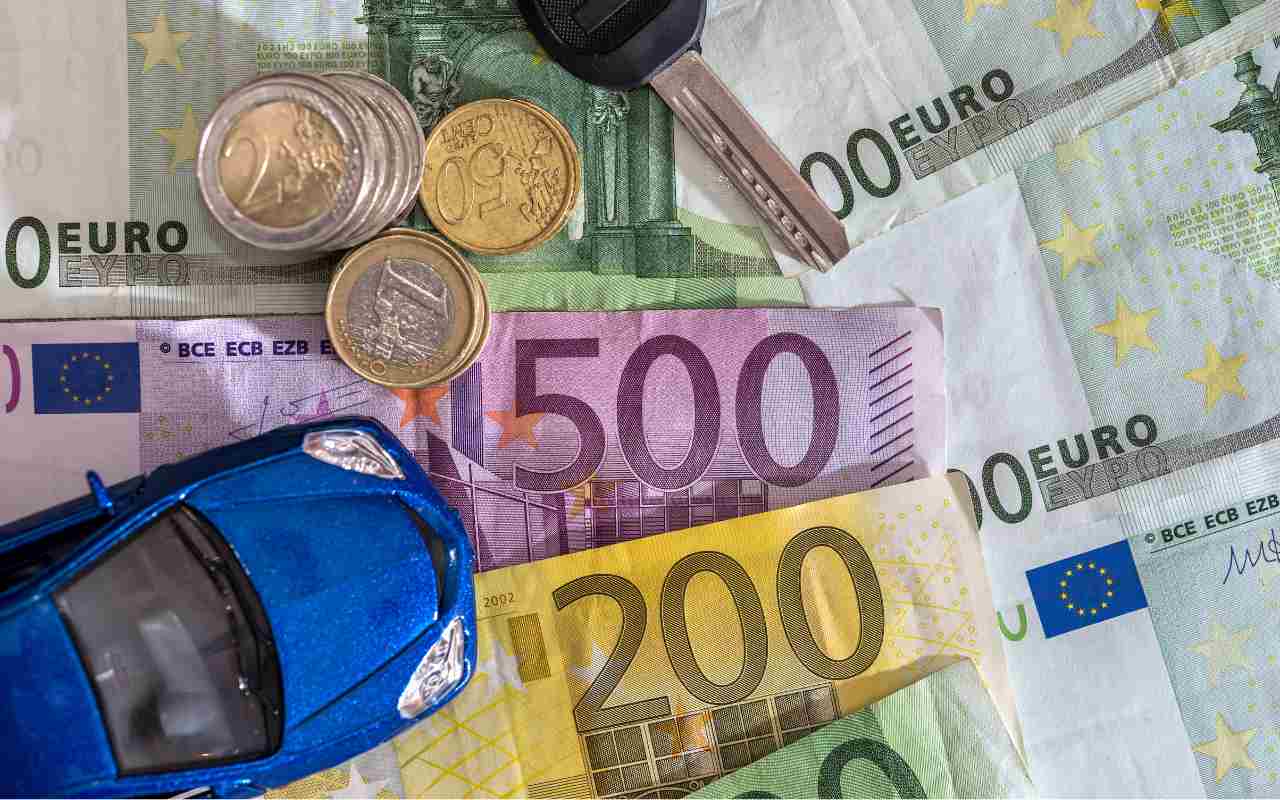 Macchina giocattolo sopra a banconote e monete euro