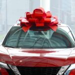 Auto rossa in concessionaria con fiocco rosso