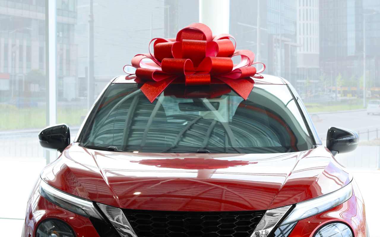 Auto rossa in concessionaria con fiocco rosso