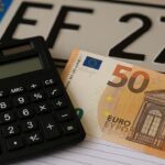 Calcolatrice, targa, banconote da 50€ e lettera di pagamento del bollo auto