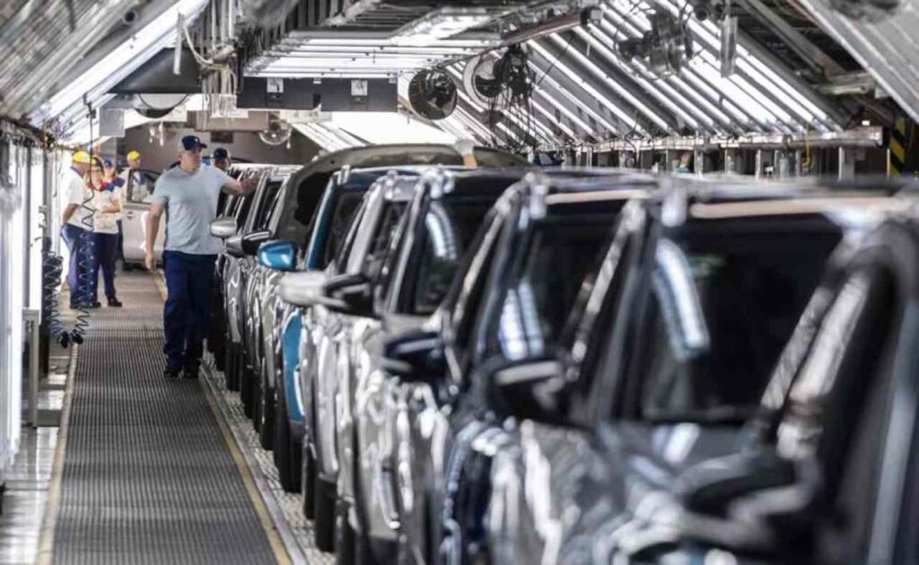 Parcheggio vuoto davanti a un edificio industriale, simbolo della fine della produzione di un’auto amata dagli italiani