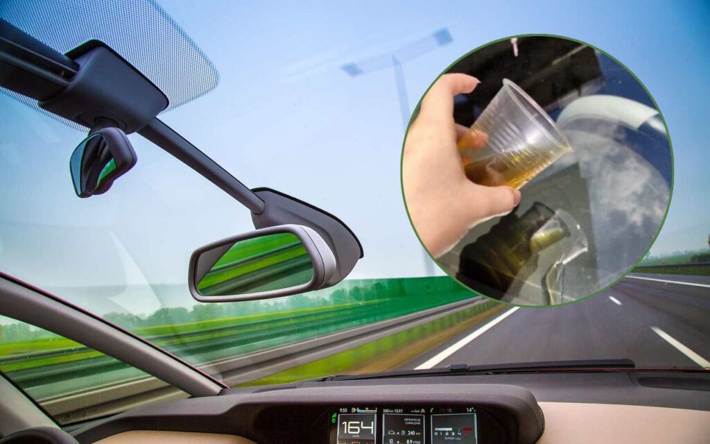 Bicchiere d'olio e parabrezza dell'auto