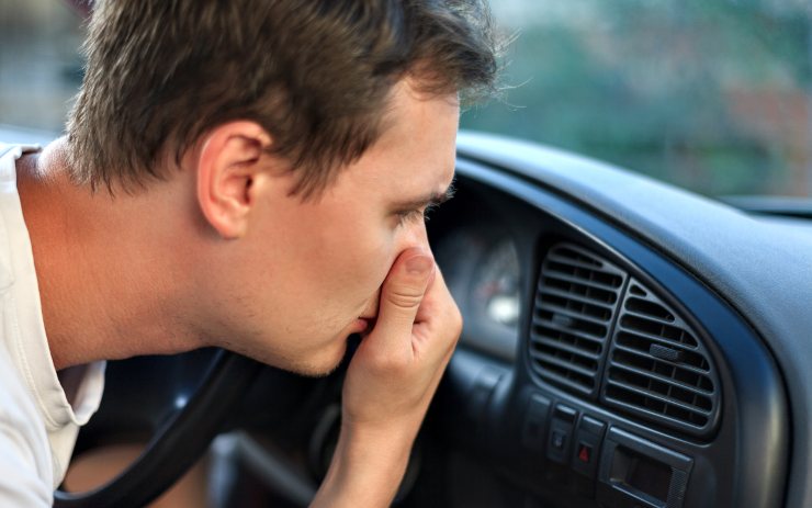 Uomo che si tappa il naso perché arriva cattivo odore dalle ventole d'aria in auto