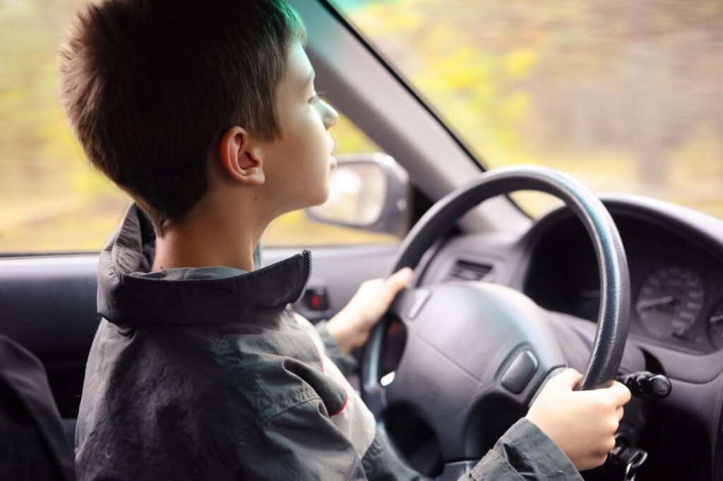 Ragazzino alla guida di un'auto