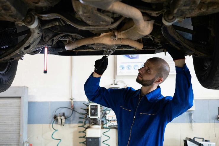 Meccanico che controlla un auto