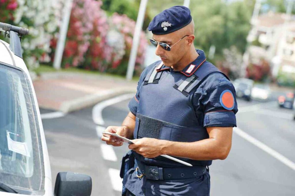 Carabiniere che guarda i documenti di un automobilista al posto di blocco