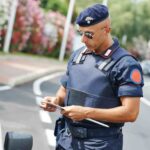 Carabiniere che guarda i documenti di un automobilista al posto di blocco