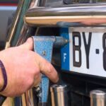 Uomo che smonta la targa della sua auto