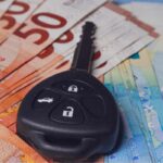 chiave auto sopra a banconote euro