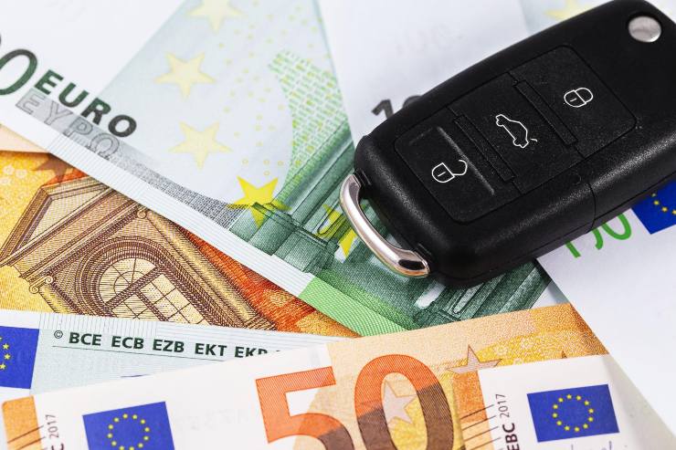 chiave auto sopra a banconote euro