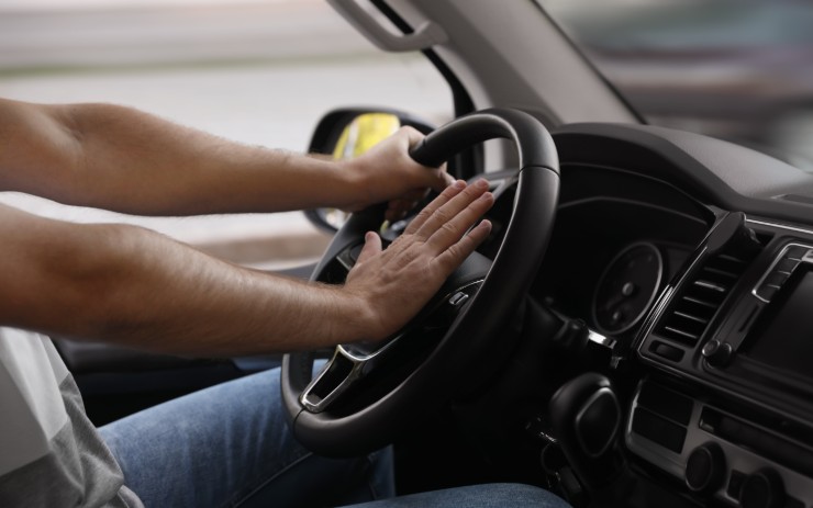 Uomo che schiaccia il clacson in auto