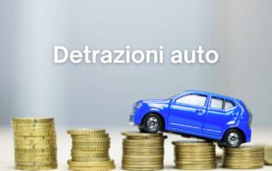 auto giocattolo che scala pile di monete e scritta "detrazioni auto"