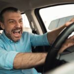 Uomo arrabbiato che schiaccia il clacson della sua auto