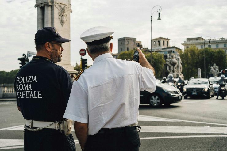 Due agenti di Polizia di Roma di schiena che osservano la circolazione